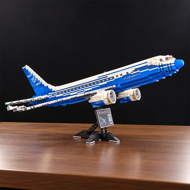 Vue de face d’une maquette du Boeing 787 Dreamliner en briques, avec moteurs détaillés, livrée bleue et blanche et support d’exposition.