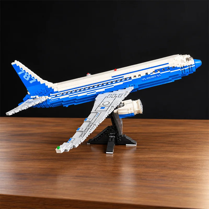Vue de face d’une maquette du Boeing 787 Dreamliner en briques, avec moteurs détaillés, livrée bleue et blanche et support d’exposition.
