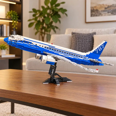 Vue de face d’une maquette du Boeing 787 Dreamliner en briques, avec moteurs détaillés, livrée bleue et blanche et support d’exposition.